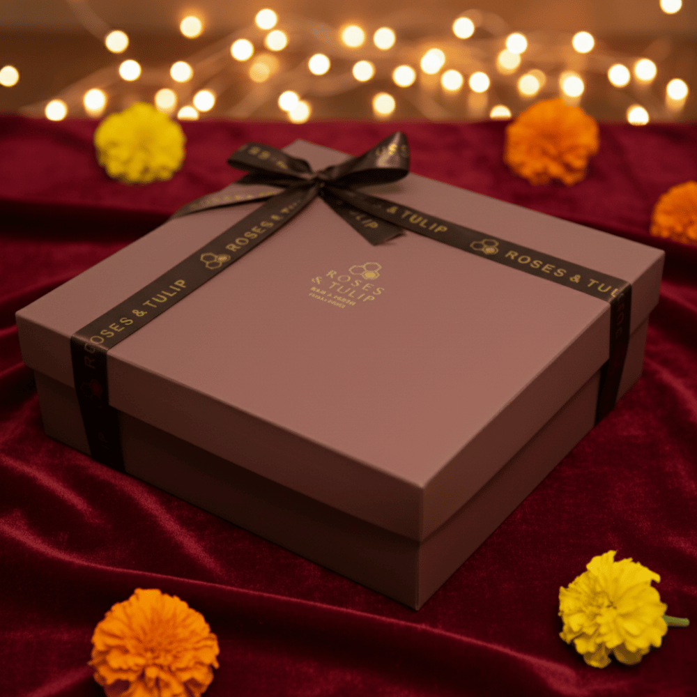 Gift box with a bow on a red fabric background with flowers