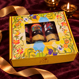 Roses & Tulip window honey gift box on plum velvet with a loose gold ribbon and glowing brass diyas.